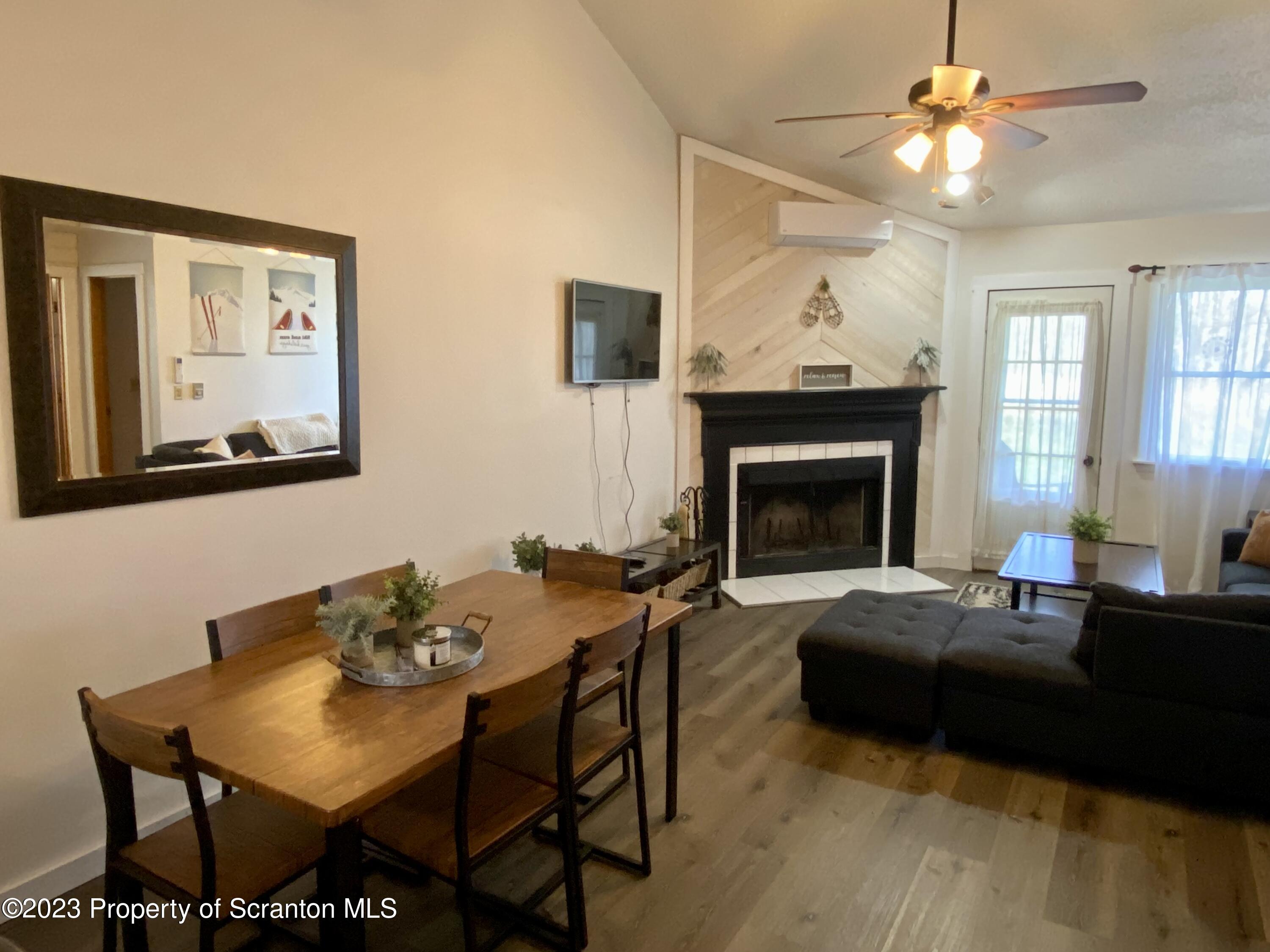 80 Garden Circle, Unit 20 Union Dale, PA 18470 - Photo 11 of 27 a living room with furniture a fireplace and a flat screen tv