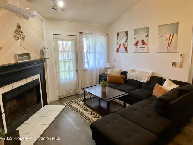 a living room with furniture a flat screen tv and a fireplace
