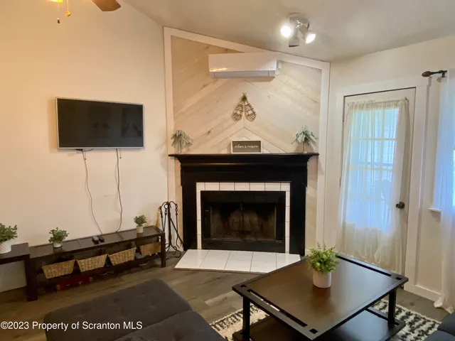 a living room with furniture a flat screen tv and a fireplace