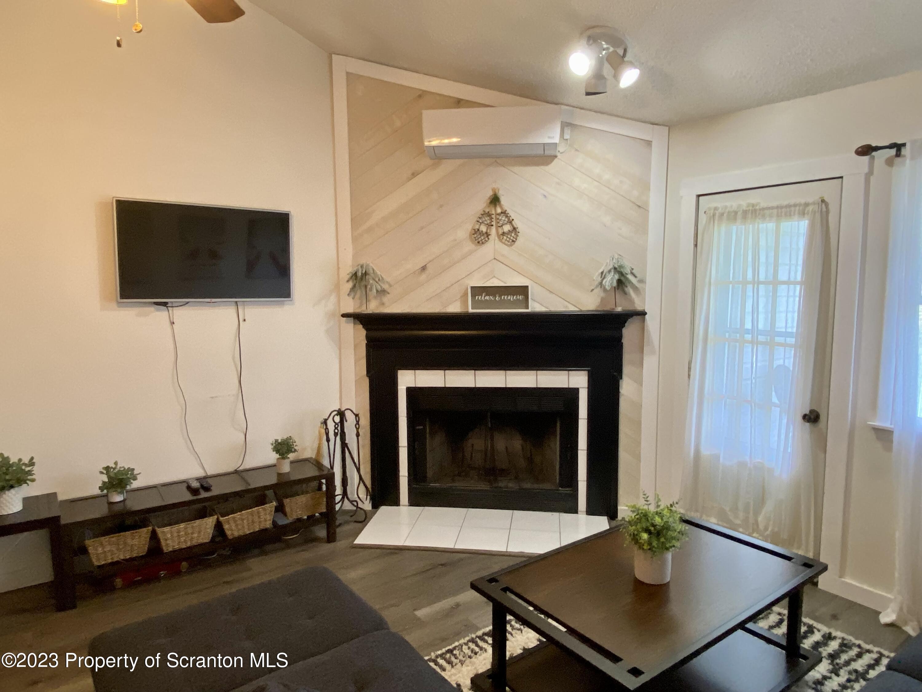 80 Garden Circle, Unit 20 Union Dale, PA 18470 - Photo 14 of 27 a living room with furniture a flat screen tv and a fireplace
