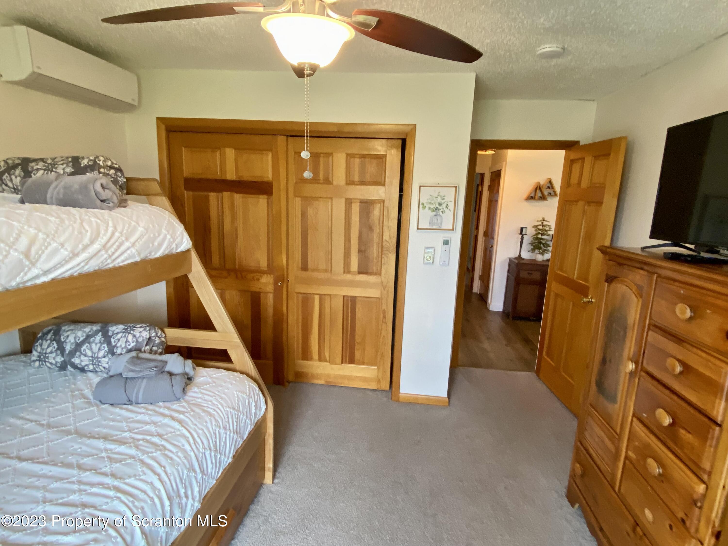 80 Garden Circle, Unit 20 Union Dale, PA 18470 - Photo 20 of 27 a bedroom with a bed and a flat tv screen