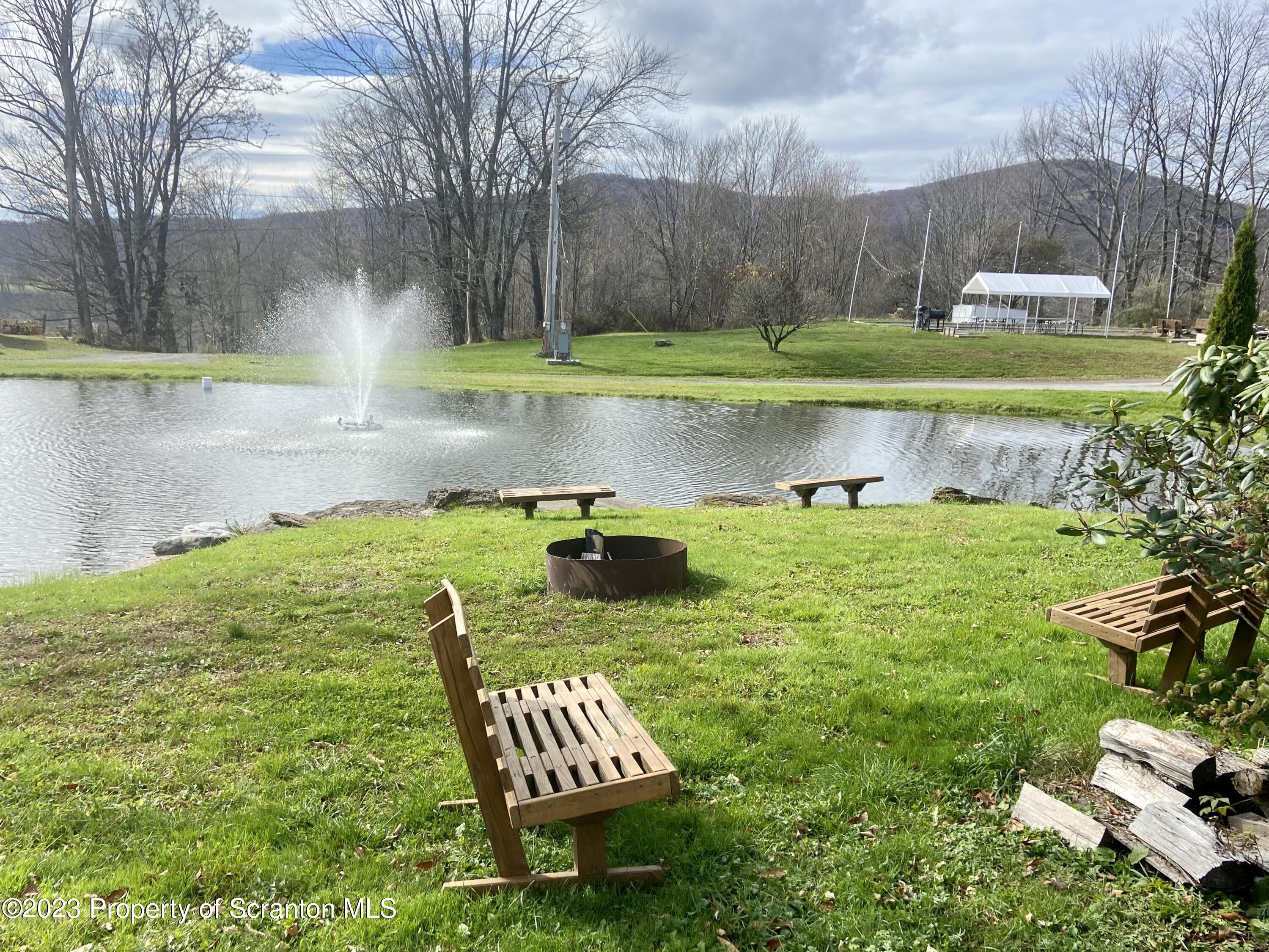 80 Garden Circle, Unit 20 Union Dale, PA 18470 - Photo 24 of 27 a view of a lake with a yard and a fountain