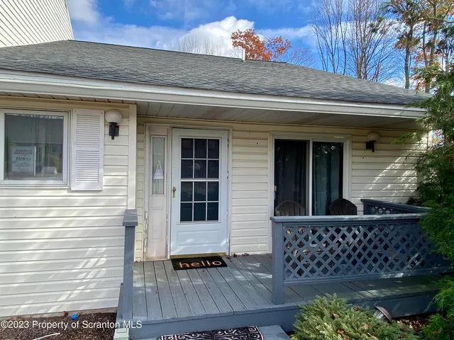 a view of house with wooden door and outdoor seating