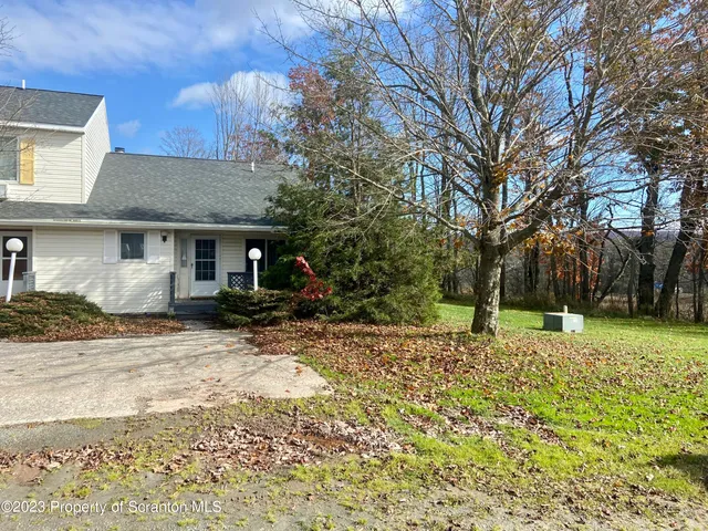a view of a house with a yard covered in snow