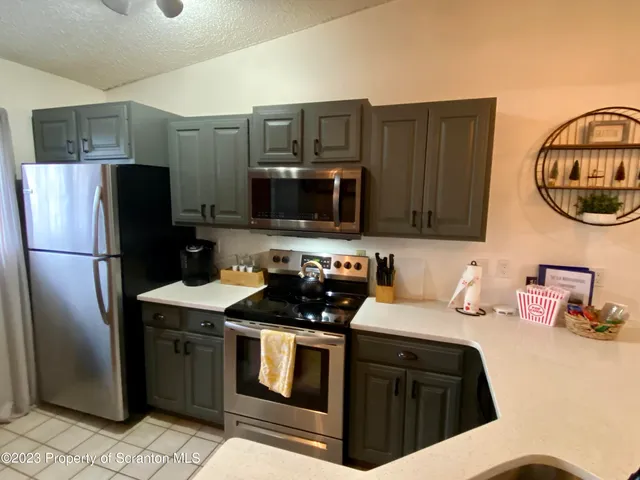 a kitchen with stainless steel appliances a refrigerator a sink a stove and a refrigerator