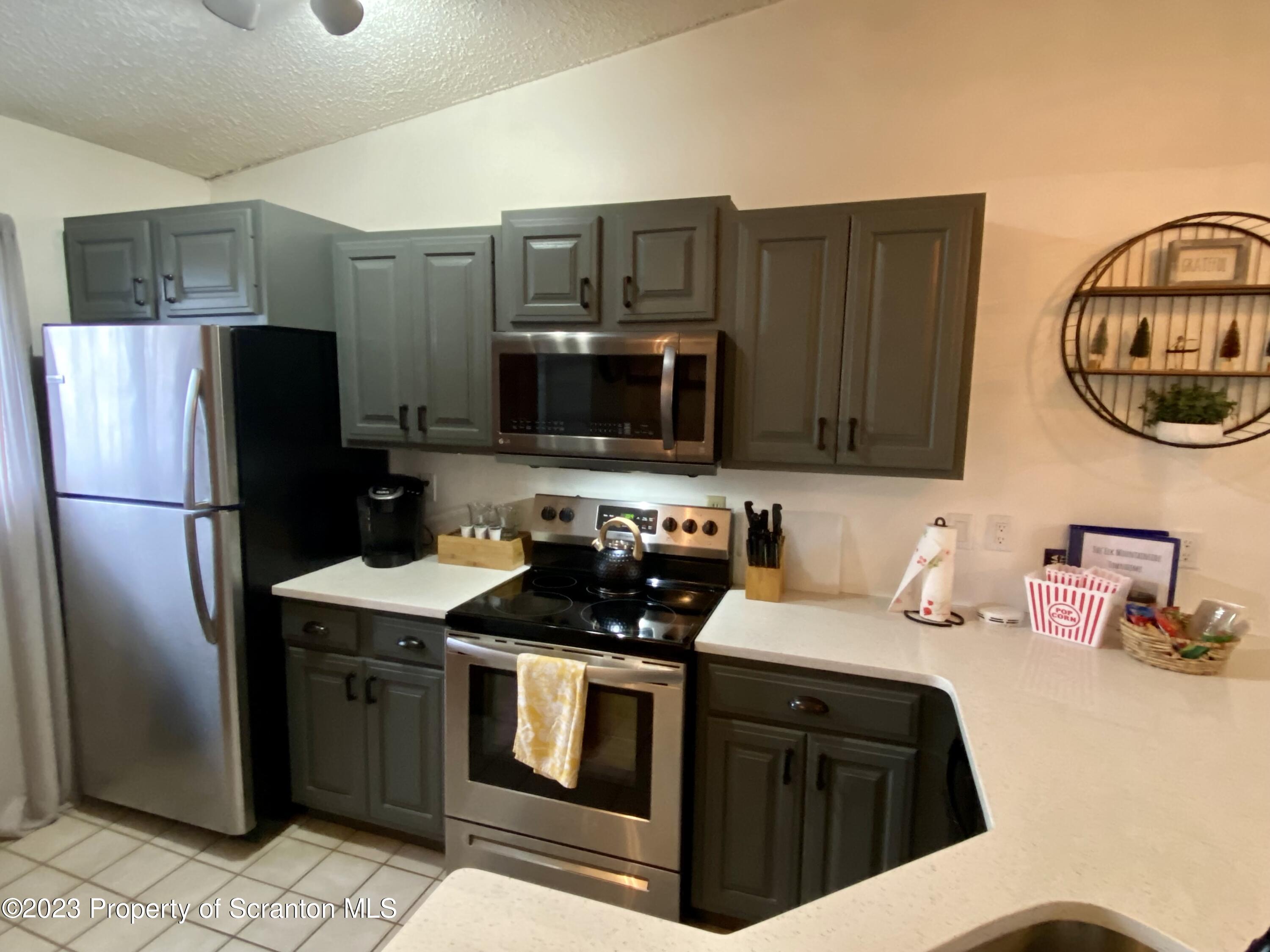 80 Garden Circle, Unit 20 Union Dale, PA 18470 - Photo 8 of 27 a kitchen with stainless steel appliances a refrigerator a sink a stove and a refrigerator