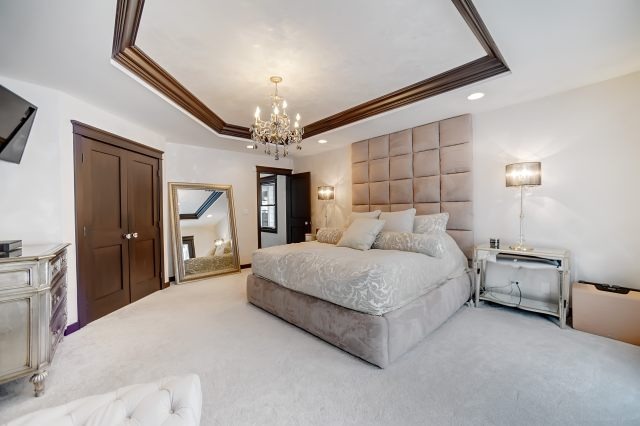2S611 Arboretum Road Glen Ellyn, IL 60137 - Photo 17 of 25 a spacious bedroom with a large bed and a chandelier