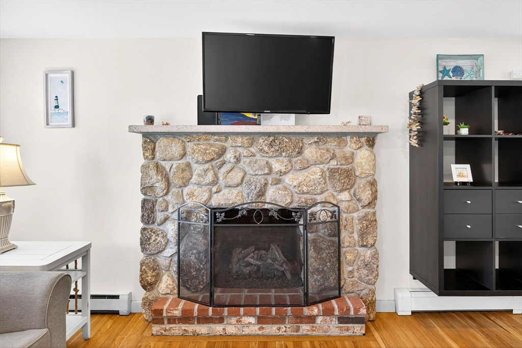 31 Easy Street Dennis, MA 02639 - Photo 4 of 41 a living room with a fireplace and a flat screen tv