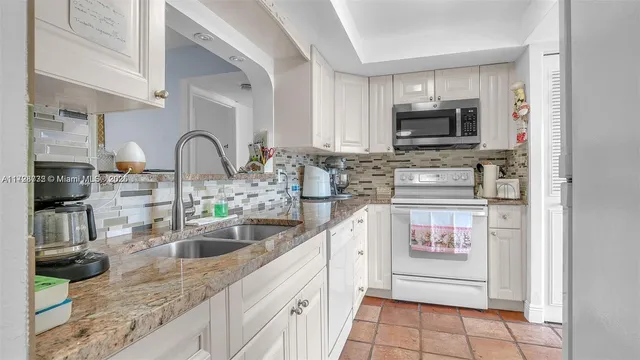 a kitchen with stainless steel appliances granite countertop a sink stove top oven and microwave