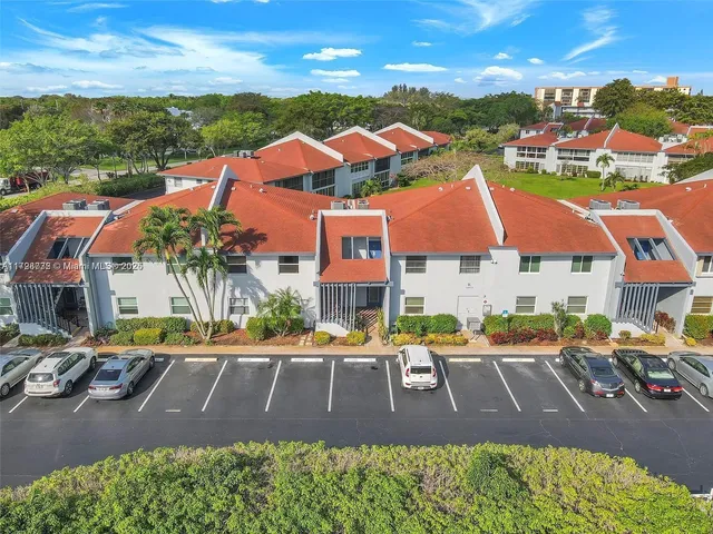 a view of a big house with a big yard and potted plants