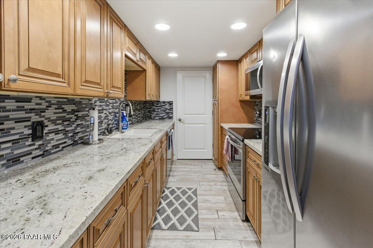 2180 Resort Way South, Unit A7 Prescott, AZ 86301 - Photo 6 of 27 a kitchen with stainless steel appliances granite countertop a sink a stove and a refrigerator