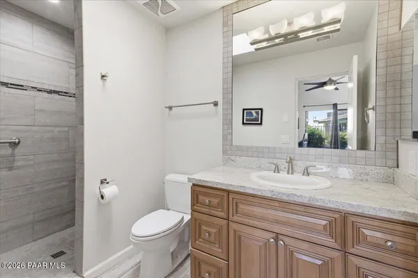 a bathroom with a granite countertop toilet sink and mirror
