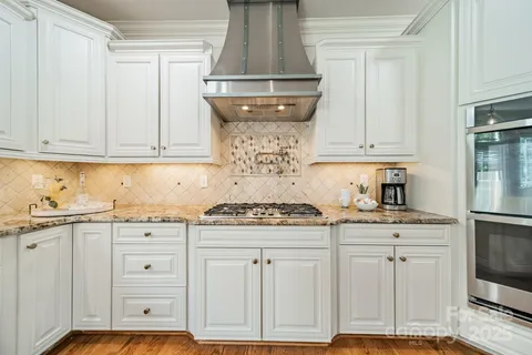 a kitchen with granite countertop white cabinets and white appliances