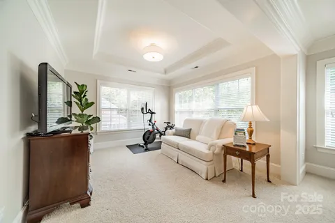 a living room with furniture a flat screen tv and a large window