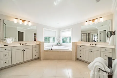 a large bathroom with a large mirror vanity sink and bathtub
