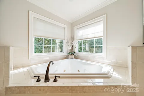 a white bath tub sitting in a bathroom next to a window