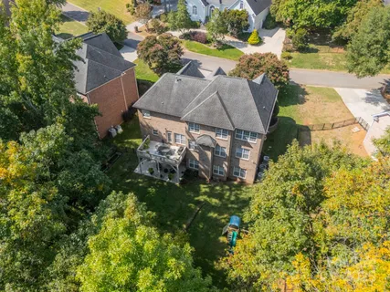 an aerial view of a house with swimming pool and garden