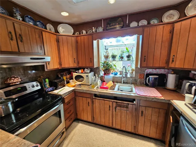 a kitchen with stainless steel appliances granite countertop a sink stove and cabinets