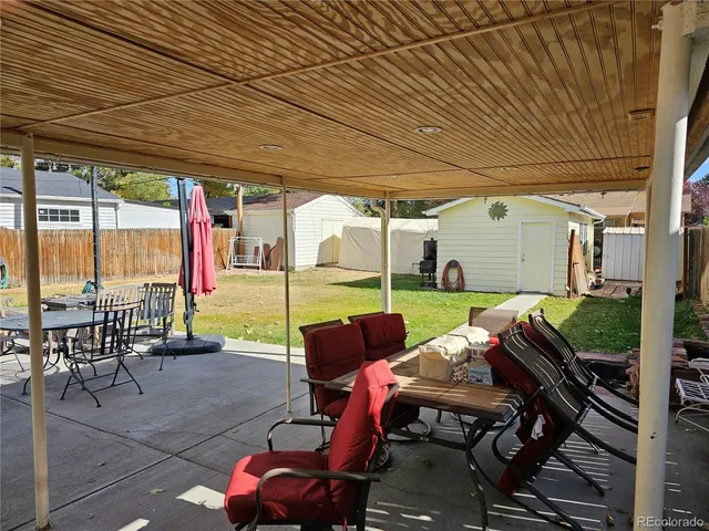 a view of a patio with table and chairs potted plants with wooden floor and fence