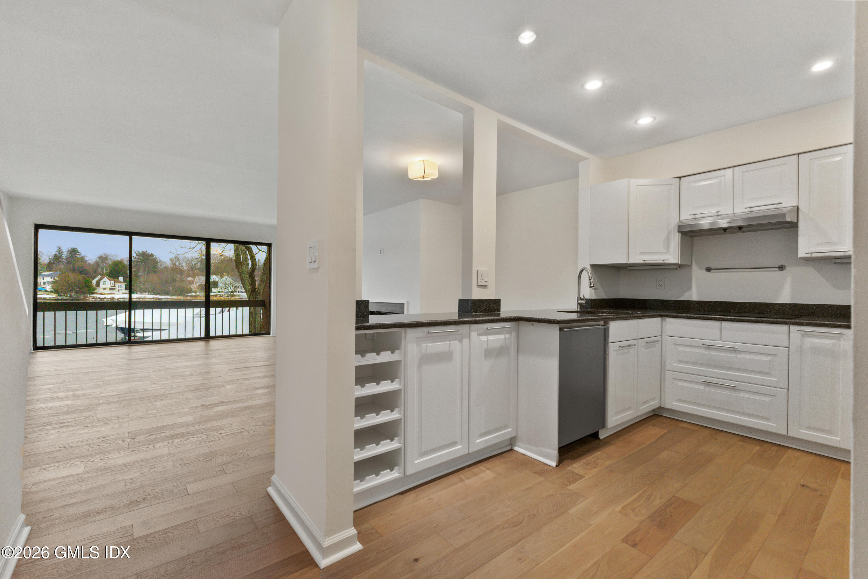15 River Road, Unit 210 Cos Cob, CT 06807 - Photo 9 of 23 a kitchen with granite countertop white cabinets and white appliances
