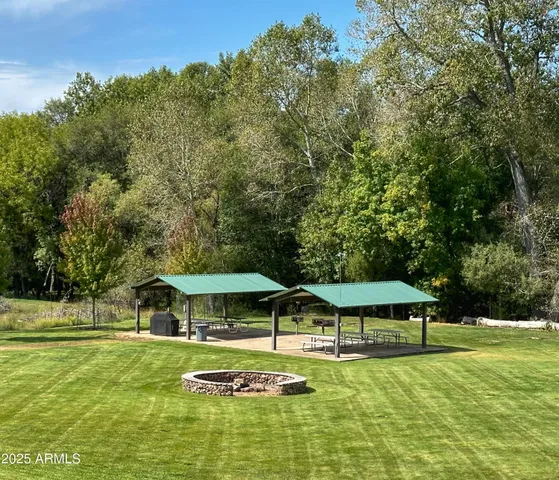 a view of a swimming pool with a table and chairs under an umbrella