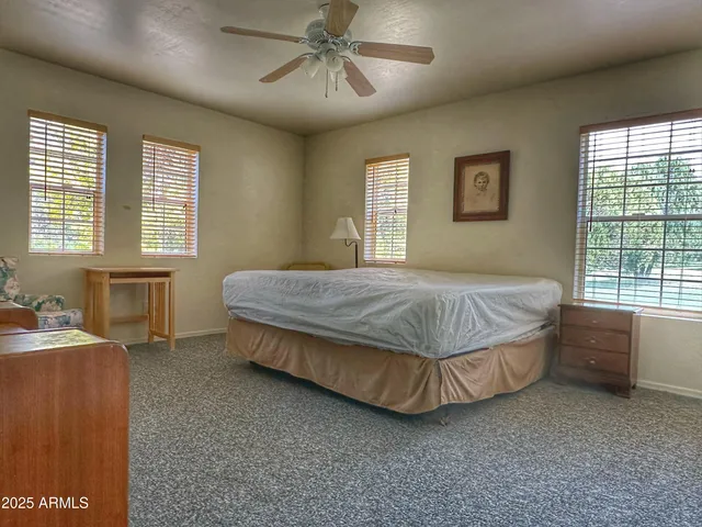 a bed sitting in a spacious bedroom next to a window
