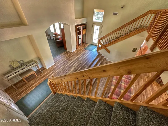 a view of staircase with wooden floor and a rug