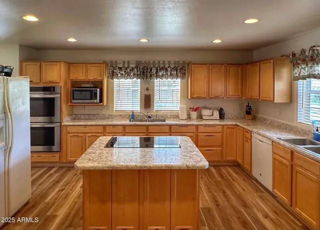 a kitchen with stainless steel appliances granite countertop a sink stove and cabinets
