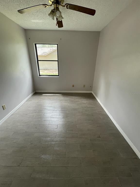 1427 Chamberlain Loop Lake Wales, FL 33853 - Photo 6 of 7 an empty room with windows and ceiling fan