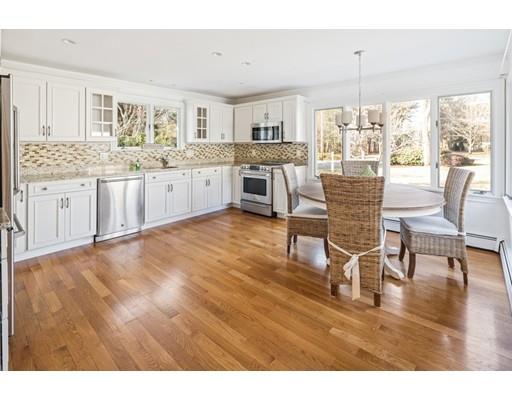 115 Prospect Street Hingham, MA 02043 - Photo 4 of 27 a large white kitchen with granite countertop a stove a sink a dining table and chairs