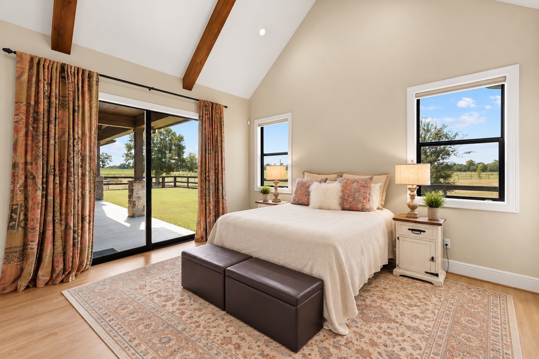 30163 High Spirit Ranch Road Hempstead, TX 77445 - Photo 19 of 46 Primary suite offers vaulted ceilings with wood-beamed accents, patio access through the sliding doors, and unreal views of the 11.55 acres.