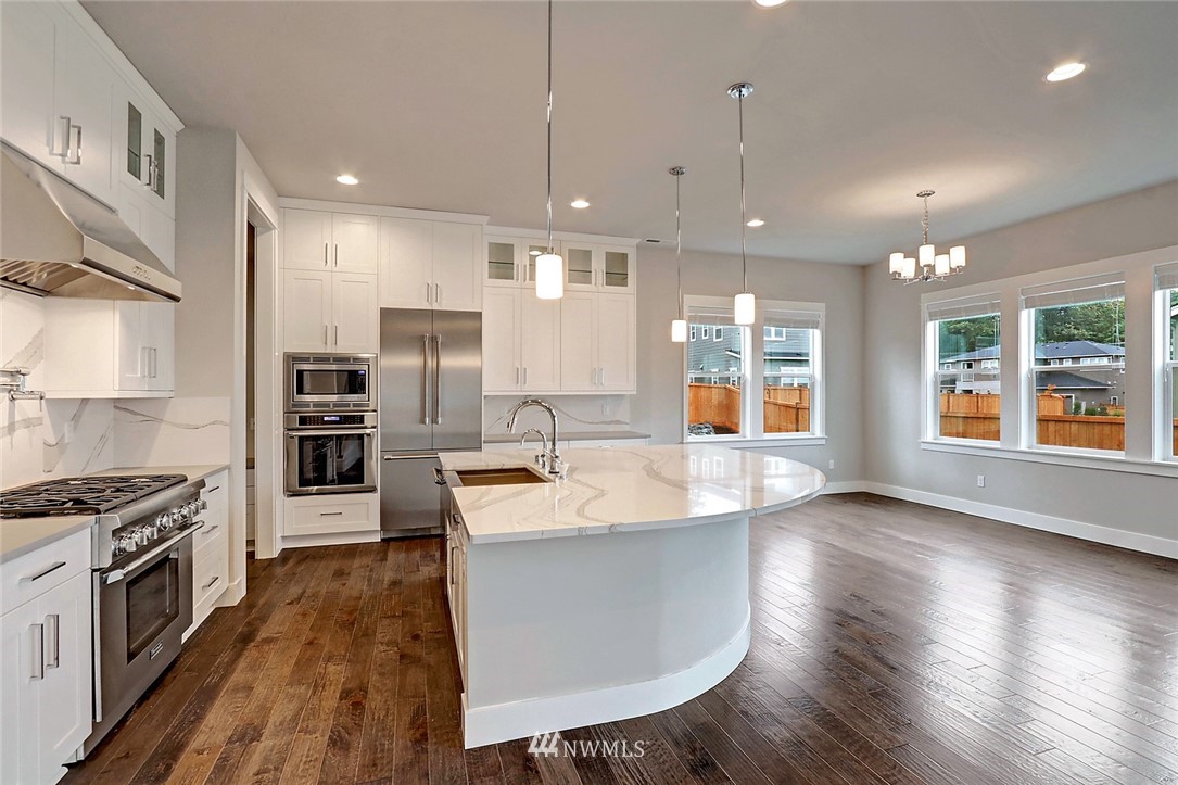 21813 33rd Drive Southeast, Unit 36 Bothell, WA 98021 - Photo 5 of 22 a large kitchen with stainless steel appliances kitchen island granite countertop a stove a sink and a refrigerator