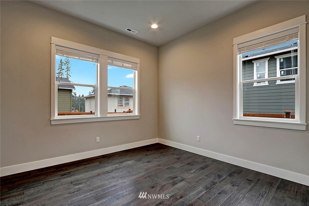 21813 33rd Drive Southeast, Unit 36 Bothell, WA 98021 - Photo 8 of 22 a view of an empty room with wooden floor and a window