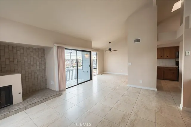 a view of an empty room with a fireplace and a window
