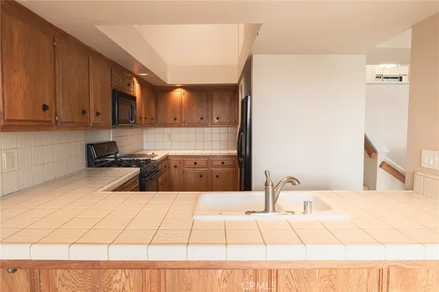 a kitchen with stainless steel appliances a sink a stove a refrigerator a cabinets a sink and a counter top space