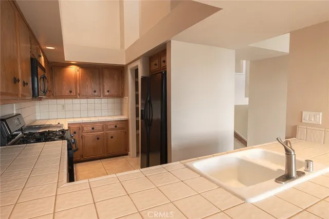 a kitchen with granite countertop a stove top oven sink and cabinets
