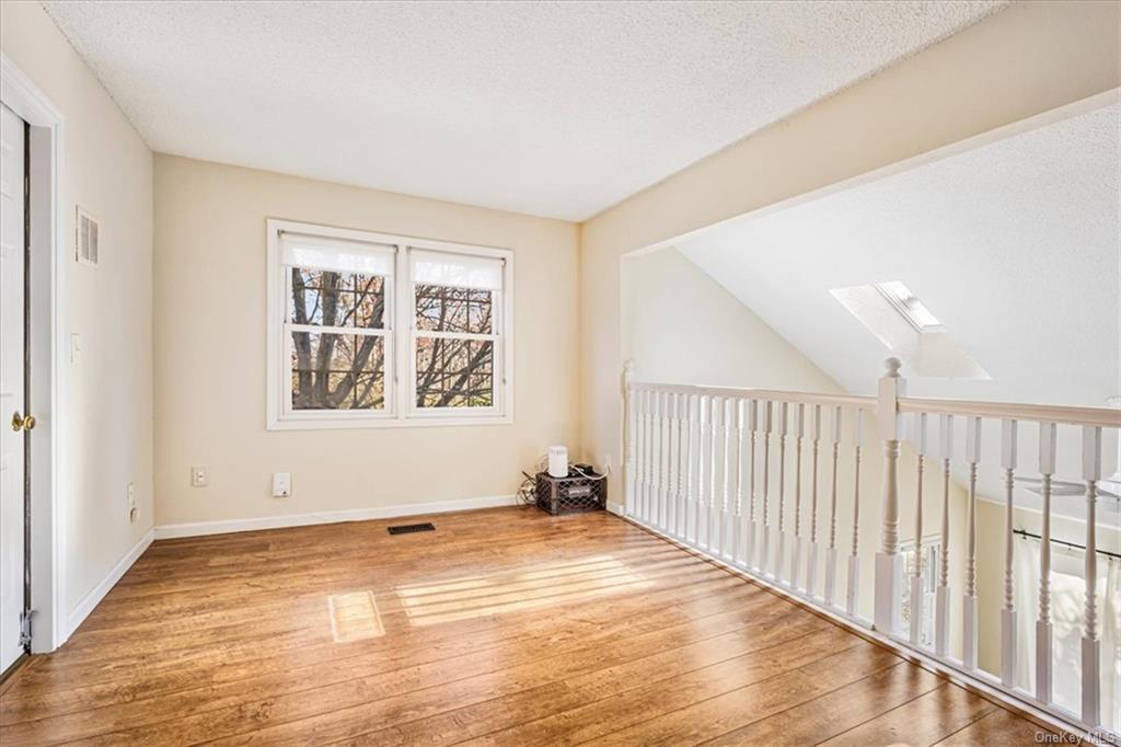 1 Chadwick Court Fishkill, NY 12524 - Photo 18 of 35 Spare room featuring lofted ceiling with skylight, a textured ceiling, and light hardwood / wood-style flooring