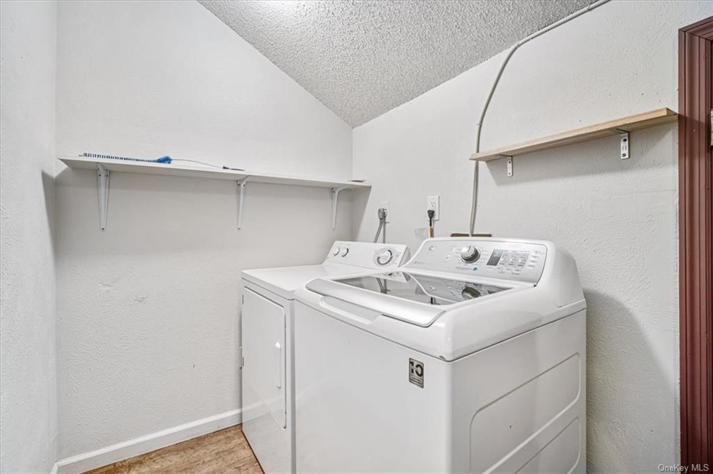 1 Chadwick Court Fishkill, NY 12524 - Photo 27 of 35 Laundry room featuring light wood-type flooring, a textured ceiling, and washing machine and clothes dryer