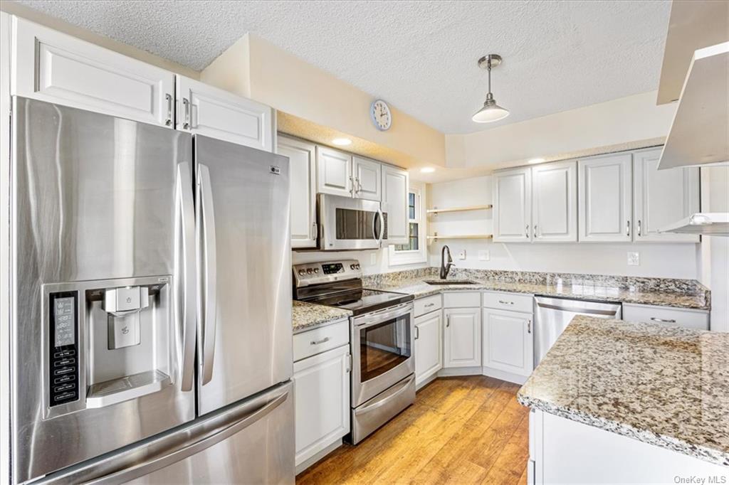 1 Chadwick Court Fishkill, NY 12524 - Photo 5 of 35 Kitchen with stainless steel appliances, sink, white cabinetry, light hardwood / wood-style flooring, and decorative light fixtures