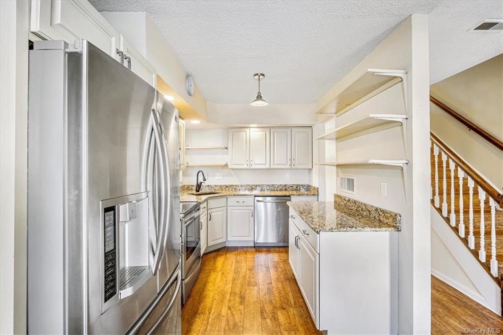1 Chadwick Court Fishkill, NY 12524 - Photo 6 of 35 Kitchen with light hardwood / wood-style floors, sink, appliances with stainless steel finishes, decorative light fixtures, and white cabinets