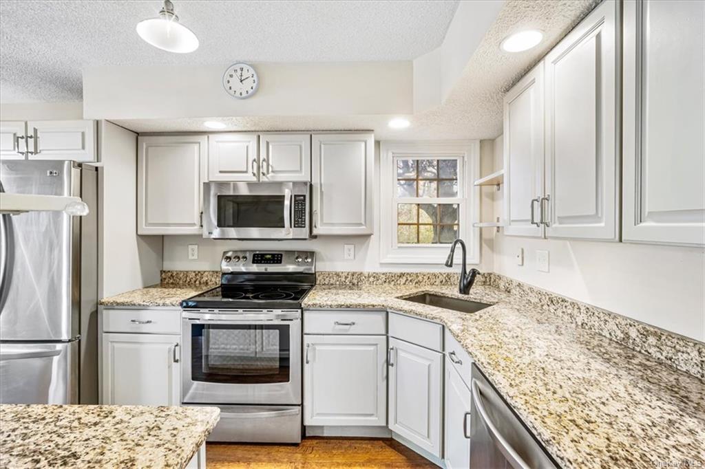 1 Chadwick Court Fishkill, NY 12524 - Photo 9 of 35 Kitchen with sink, white cabinetry, a textured ceiling, and stainless steel appliances