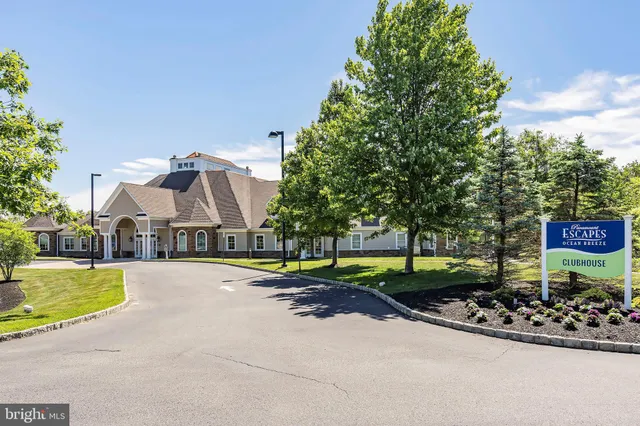 a front view of a house with a garden and lake view
