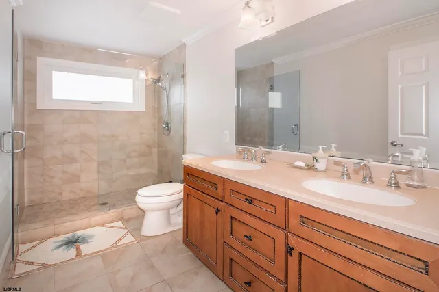 a bathroom with a double vanity sink toilet mirror and shower