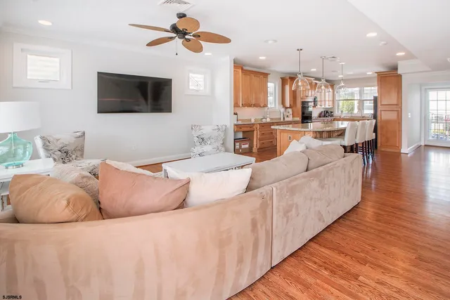 a living room with furniture kitchen view and a flat screen tv