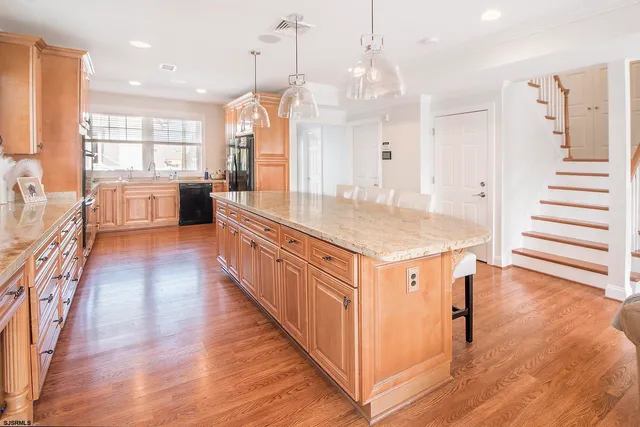 a kitchen with stainless steel appliances granite countertop a sink a counter top space and a center island