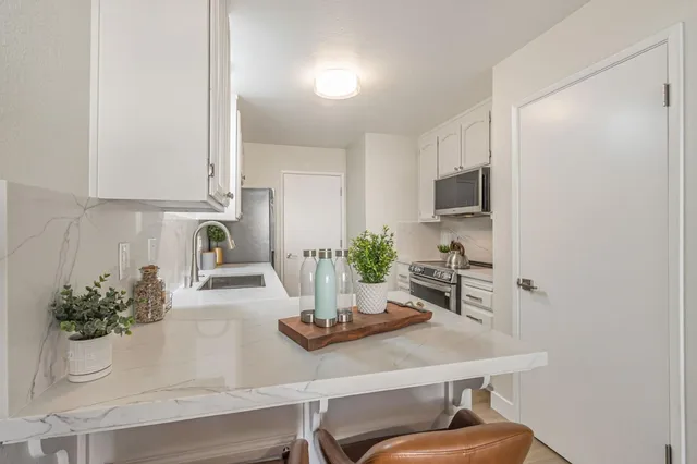 a view of kitchen with sink and refrigerator