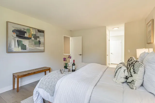 a bedroom with a bed and a painting on the wall