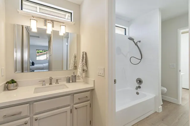 a bathroom with a tub a sink and mirror