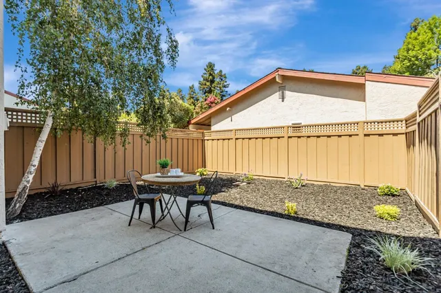 a backyard of a house with table and chairs