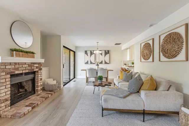 a living room with furniture a fireplace and a window